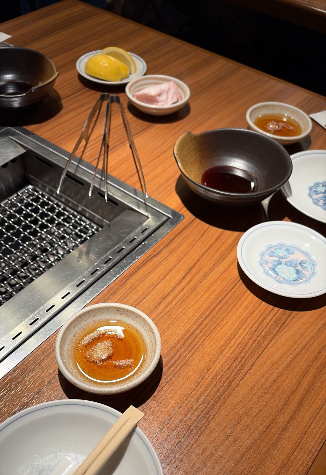 焼く前の卓上。網とタレと小皿が並んでいる